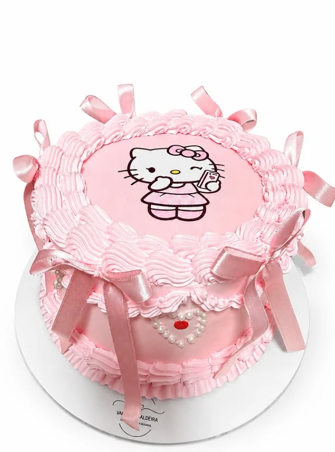 Bolo personalizado rosa com laços de cetim, pérolas e desenho da Hello Kitty